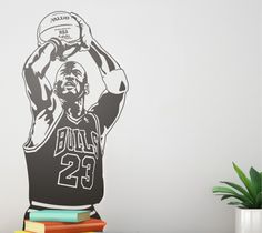 a black and white wall decal of a basketball player with his hands up in the air