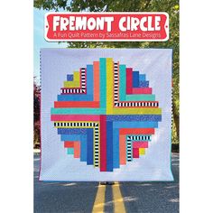 the front cover of fremont circle quilt book, featuring an image of a colorful cross