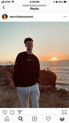 a man standing in front of the ocean at sunset with his hands in his pockets