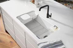 a white kitchen sink sitting on top of a counter