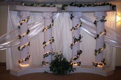 a room with white curtains and lights on the windowsills is decorated for christmas