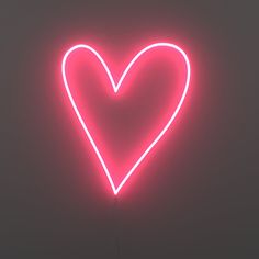 a heart shaped neon sign in the middle of a dark room with no one around it