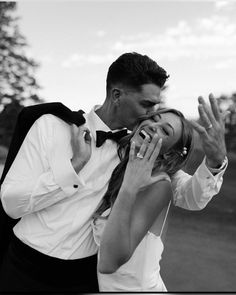 a man and woman kissing each other in black and white