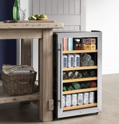 an open refrigerator sitting next to a wooden table