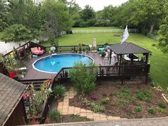 an aerial view of a backyard with a pool, deck and hot tub in the middle