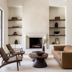 a living room filled with furniture and a fire place in the middle of a room