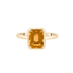 a yellow gold ring with an orange topazte stone in the center, on a white background