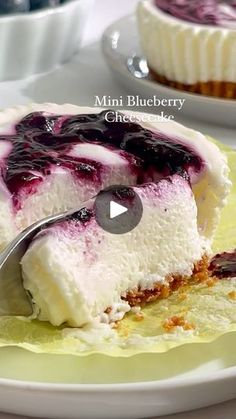 a piece of cheesecake with blueberry sauce on it and a fork in the middle