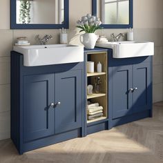 a bathroom with two sinks and blue cabinets