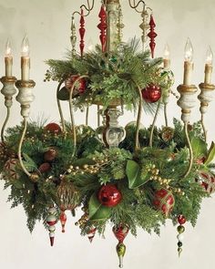 a chandelier is decorated with greenery and candles for the holiday season in this instagram