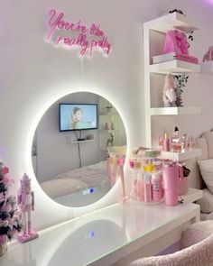 a room that has a mirror on the wall and pink decorations around it in front of a tv