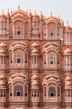 an ornate pink building with many windows and balconies