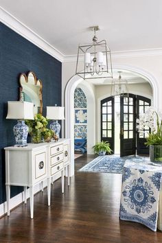 a living room with blue and white decor on the walls, wood flooring and an arched doorway