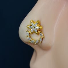 a close up view of a nose with an earring made out of gold and diamonds