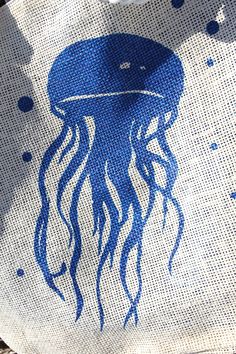 "Jelly Fish Beach Tote BBG-Jf Size approx: 17\"w x 15 1/2\" t Made from 100% polyester, wont wrinkle Made in China. Marketed and housed in the USA interior is lined with blue to match the jelly fish pleated bottom for ample room which helps the bag to stand up extra large grommets holds the soft white ropes handles lease let us know that this is a gift and we will include a card with your message. For returns please refer to the flyers included in your shipments. We no longer ship to Puerto Rico Beachy Painted Tote Bags, Beach Bag Painting Ideas, Beach Tote Bags Diy Paint, Tote Bag Painting Ideas Beach, Summer Tote Bag Design, Beach Bag Ideas, Beach Tote Bags Diy, Diy Bag Painting, Fish Tote Bag