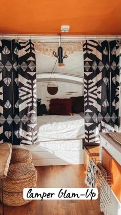 the interior of a bedroom with black and white decor on the walls, wood flooring and an orange painted ceiling