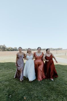 four bridesmaids posing for a photo in the grass