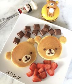 a plate topped with pancakes and teddy bears made to look like they are eating strawberries