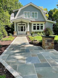 a stone walkway leads to the front door of a house