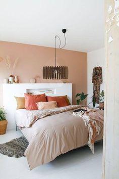 a bed sitting in a bedroom next to a wall with plants on top of it