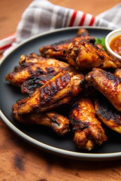 chicken wings with dipping sauce on a black plate