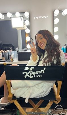 a woman sitting in a chair with a mirror behind her and the words jimmy kimmel live written on it