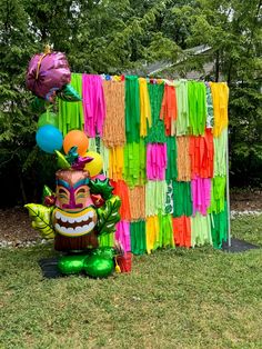 an elaborately decorated lawn decoration with balloons and streamers in the shape of a tiki