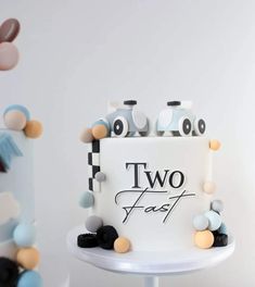 a two - tiered cake is decorated with colorful candies and polka dot decorations