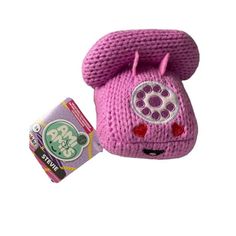 a pink knitted phone with ears on it's side and a candy bar in front