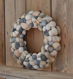 a wreath made out of seashells sitting on top of a wooden wall