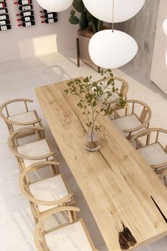 a wooden table with chairs around it and a plant in the center on one end