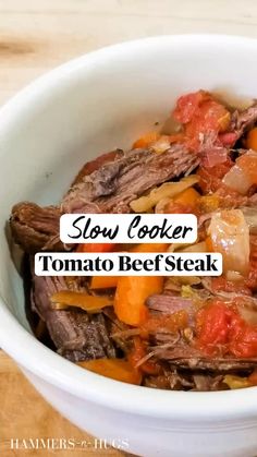 slow cooker tomato beef steak in a white bowl on a wooden table with text overlay