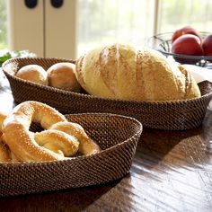 two baskets filled with bagels sitting on top of a wooden table