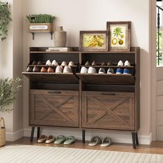 a wooden shoe rack filled with shoes next to a potted plant on top of a hard wood floor