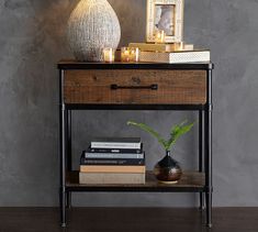 a wooden table topped with books and a vase