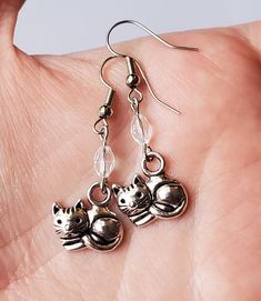 Fun and simple dangle earrings. These feature a curled up cat with a small clear faceted charm. Perfect for a gift for the cat lover in your life! Metal Cat Design Drop Earrings, Curled Up Cat, Simple Dangle Earrings, Silver Cat, Cat Charm, Earrings Cute, Cat Earrings, Cute Gift, Earrings Silver