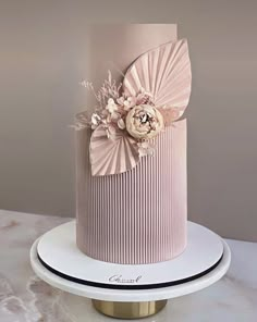 a pink and white cake with flowers on top