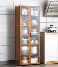 a wooden cabinet filled with lots of dishes next to a wall mounted stove top oven