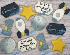 some decorated cookies that are on top of a wooden table with stars and moon in the background