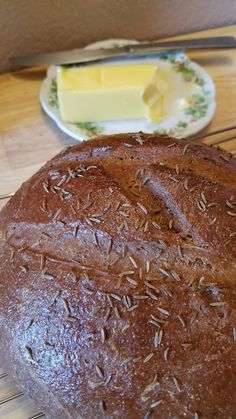 a loaf of bread sitting on top of a table next to a plate with butter