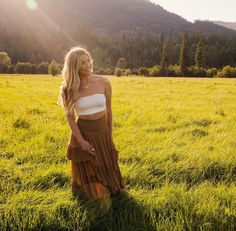 a woman is standing in the middle of a field