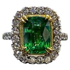 an emerald and diamond ring set in yellow gold