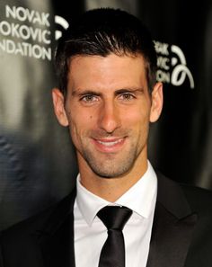 a man in a suit and tie smiling at the camera