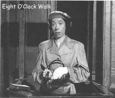 an old black and white photo of a woman in uniform holding a hat with the caption eight o'clock walk