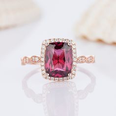 a pink diamond ring with diamonds surrounding it