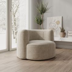 a living room with white walls and wood flooring, a round chair in front of a large window