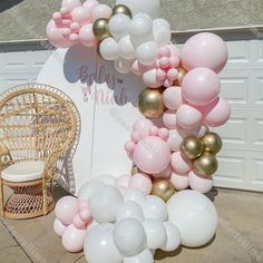 a balloon arch is decorated with pink, white and gold balloons