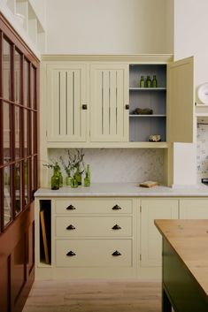 a kitchen with white cabinets and wood floors