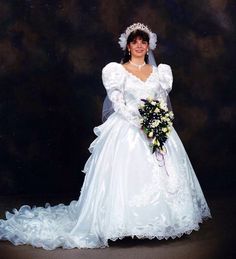 a woman in a wedding dress posing for a photo