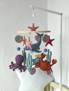 a white mannequin head with an octopus, starfish and seahorse mobile hanging from it's side